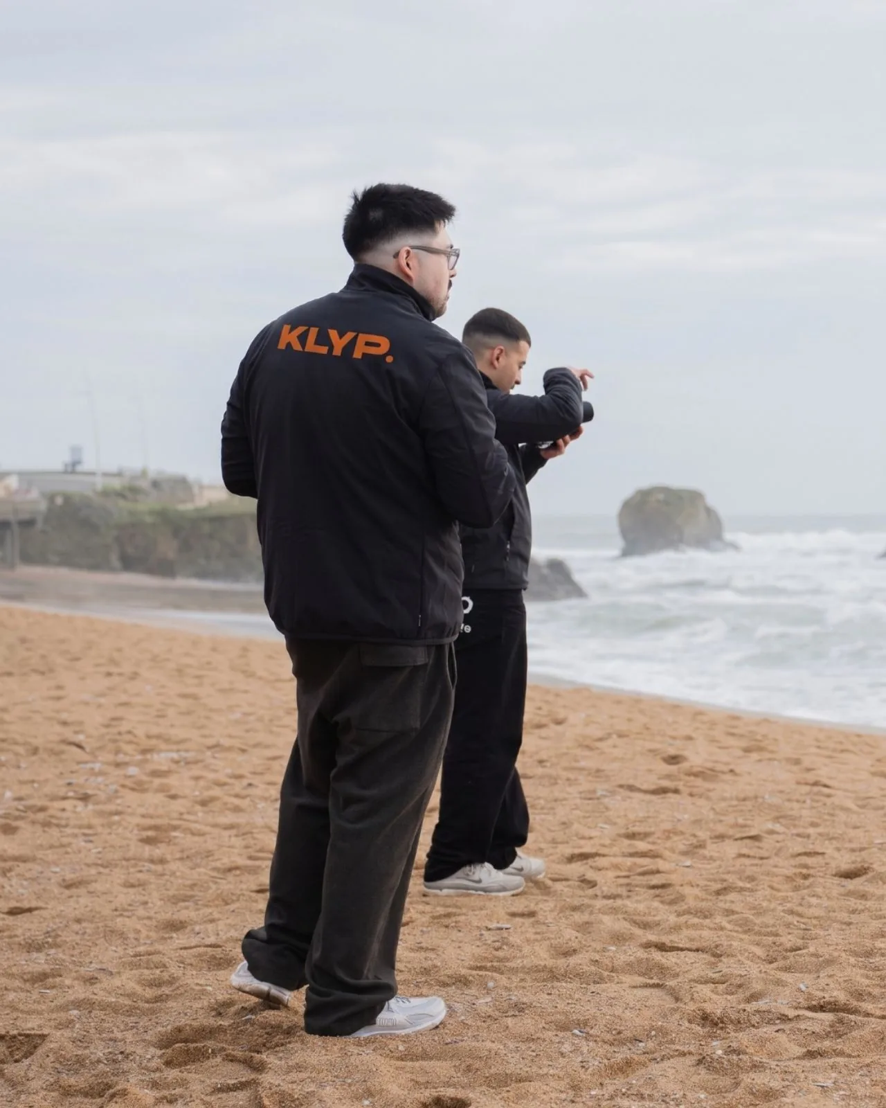 Deux membres de l'équipe Klyp en tournage sur une plage