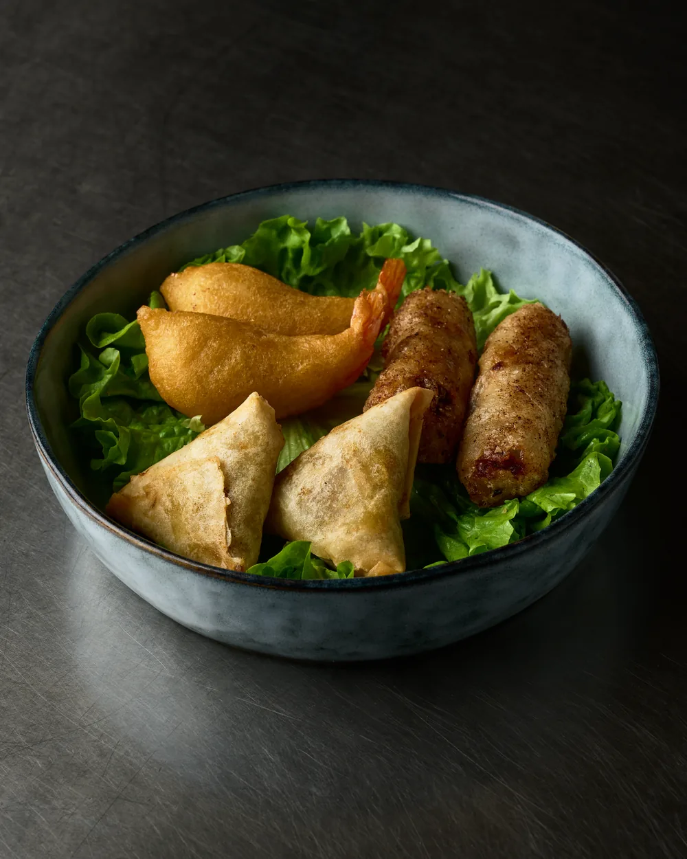 Assortiment de fritures asiatiques sur lit de salade : nems, samossas et beignet de crevette