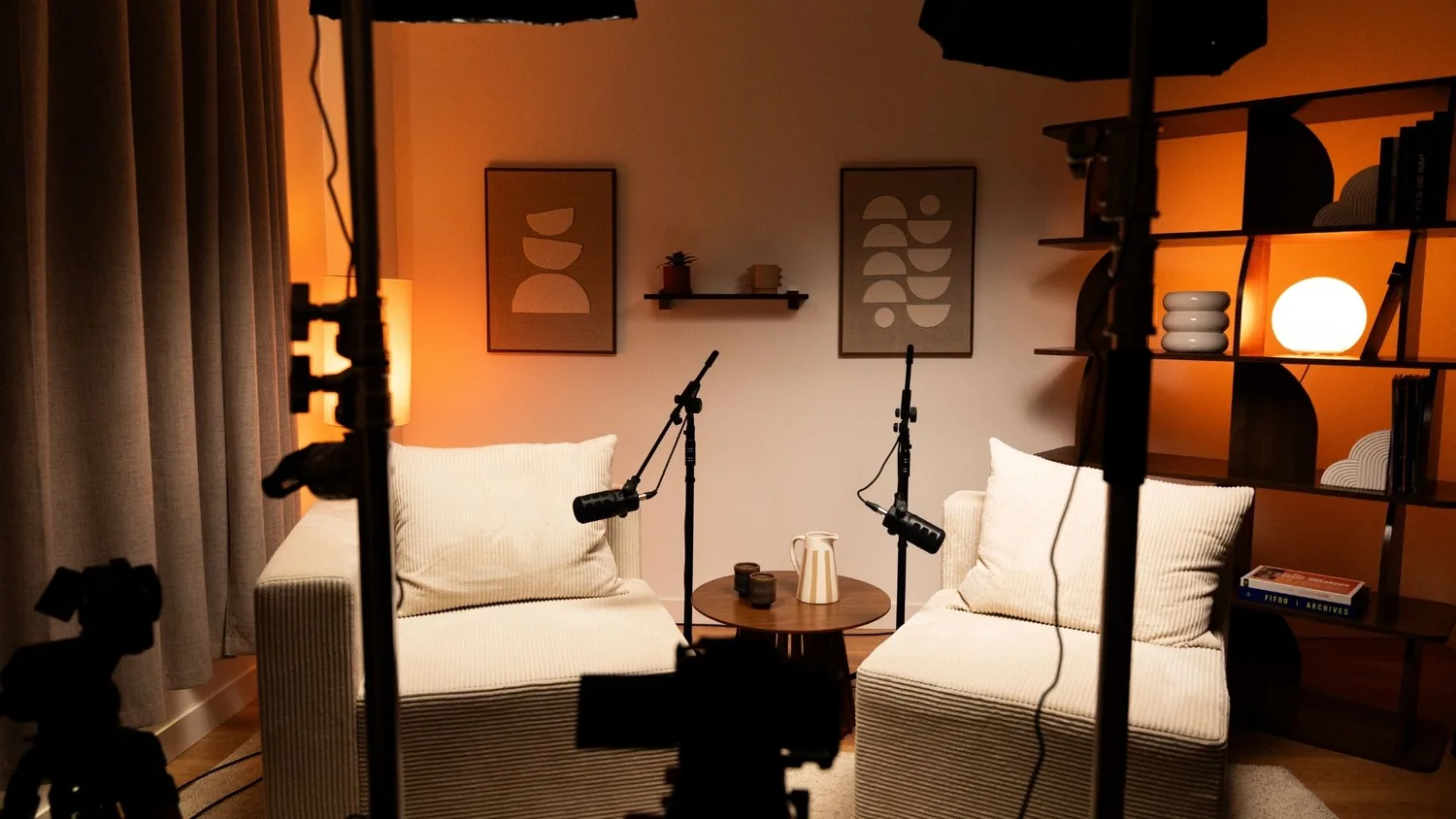 Plateau podcast du studio Klyp : deux fauteuils en velours côtelé, deux micros sur pied et une décoration chaleureuse