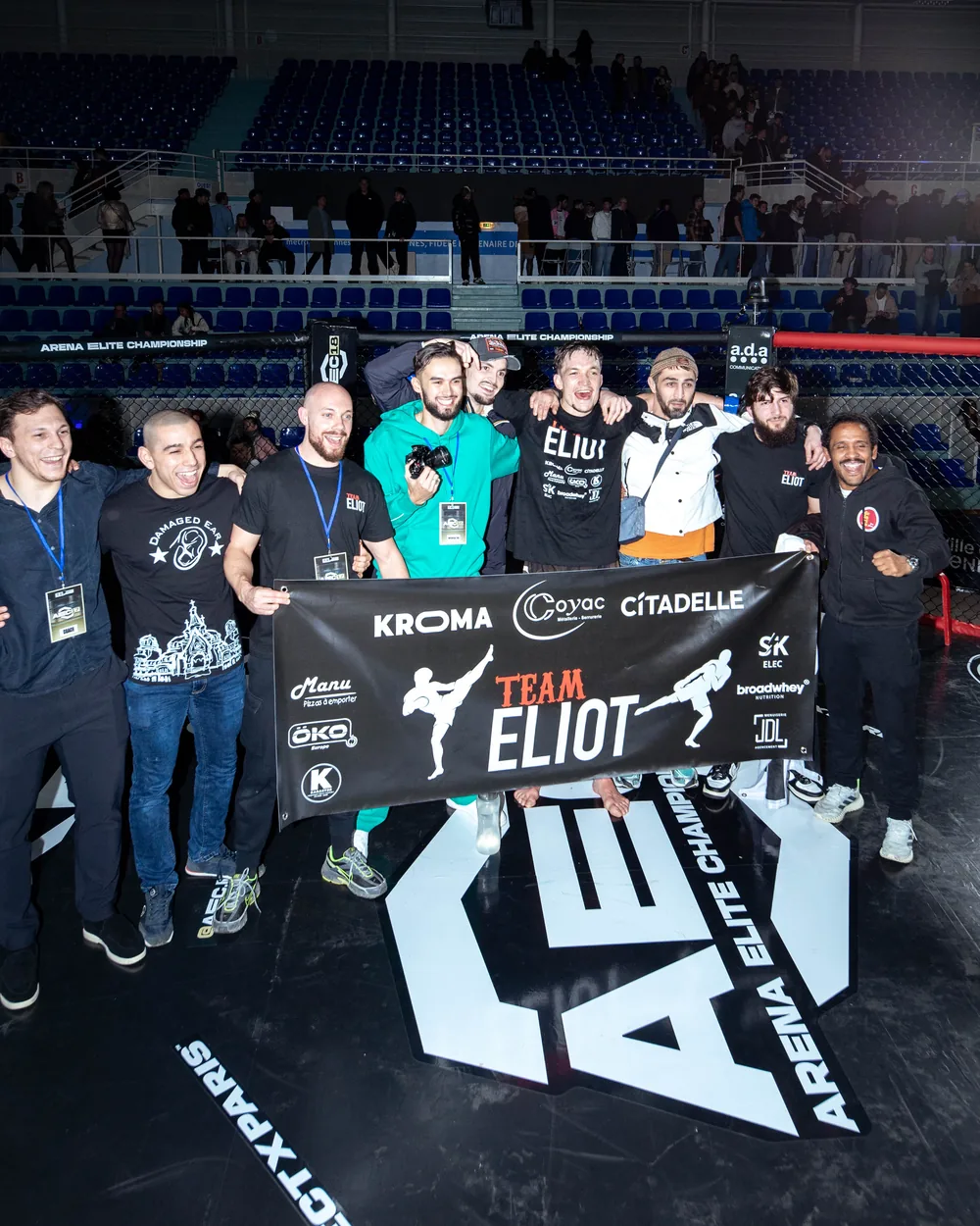 Photo de groupe du staff derrière la bannière Team Eliot, à l’issue de la soirée