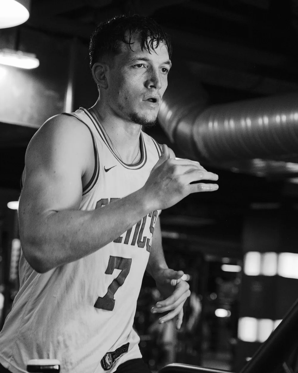 Basketteur bras tendu lançant une passe, en noir et blanc